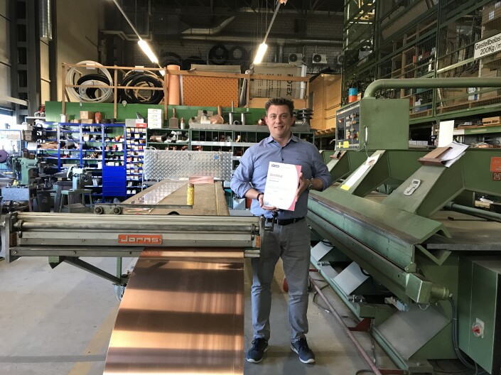 Andreas Meyer, Geschäftsführer der Emil Landsrath AG mit dem Label iPunkt-Zertifikat. Im Hintergrund ist die Werkstatt. 