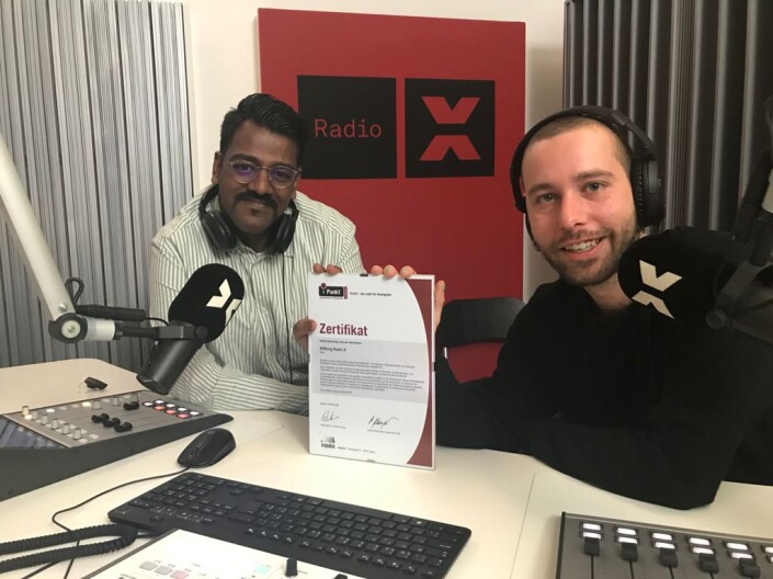 Subagesh Karunakaran und Simon Baumann von der Stiftung Radio X und halten das iPunkt-Zertifikat in die Kamera.