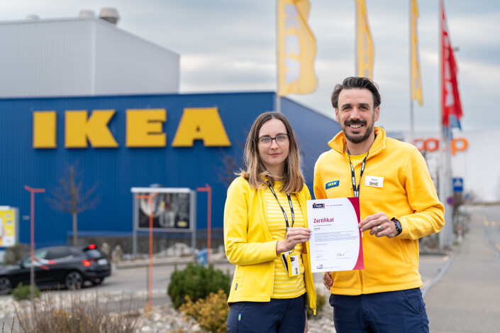 Valerie Tellenbach, People & Culture Generalistin und David Llaneza, People & Culture Manager, mit dem iPunkt Zertifikat vor dem IKEA Pratteln