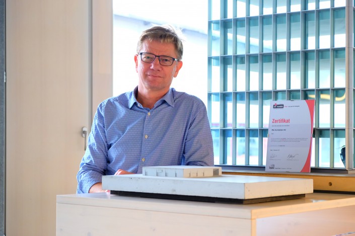 Das Foto zeigt ffbk Architekten AG Geschäftsführer Jan Krarup mit dem Label iPunkt Zertifikat